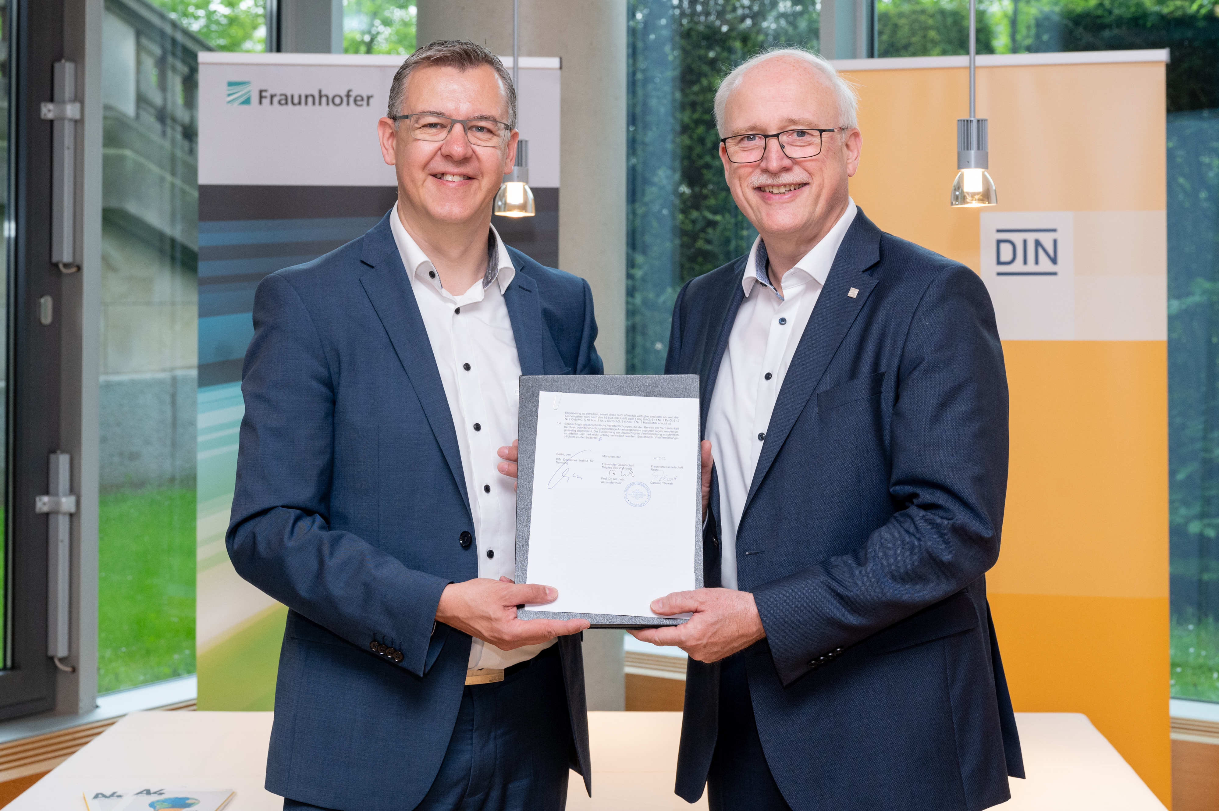 Prof. Alexander Kurz, Executive Board Member and Vice President for Innovation, Transfer and IP Management at the Fraunhofer-Gesellschaft and Christoph Winterhalter, DIN Executive Board Chairman, sign the cooperation agreement. Bild